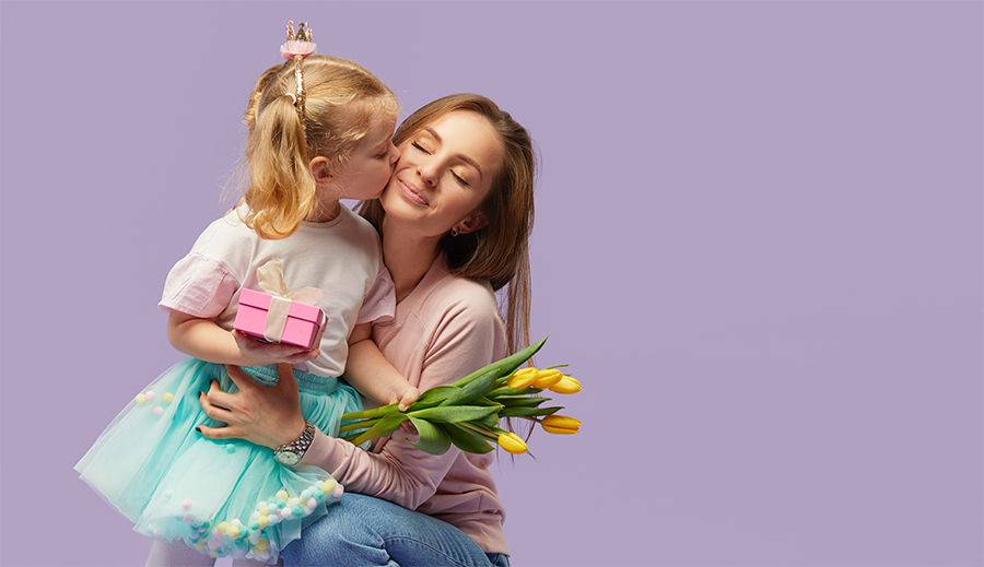 Muttertag Kind küsst Mama mit Blumen in der Hand